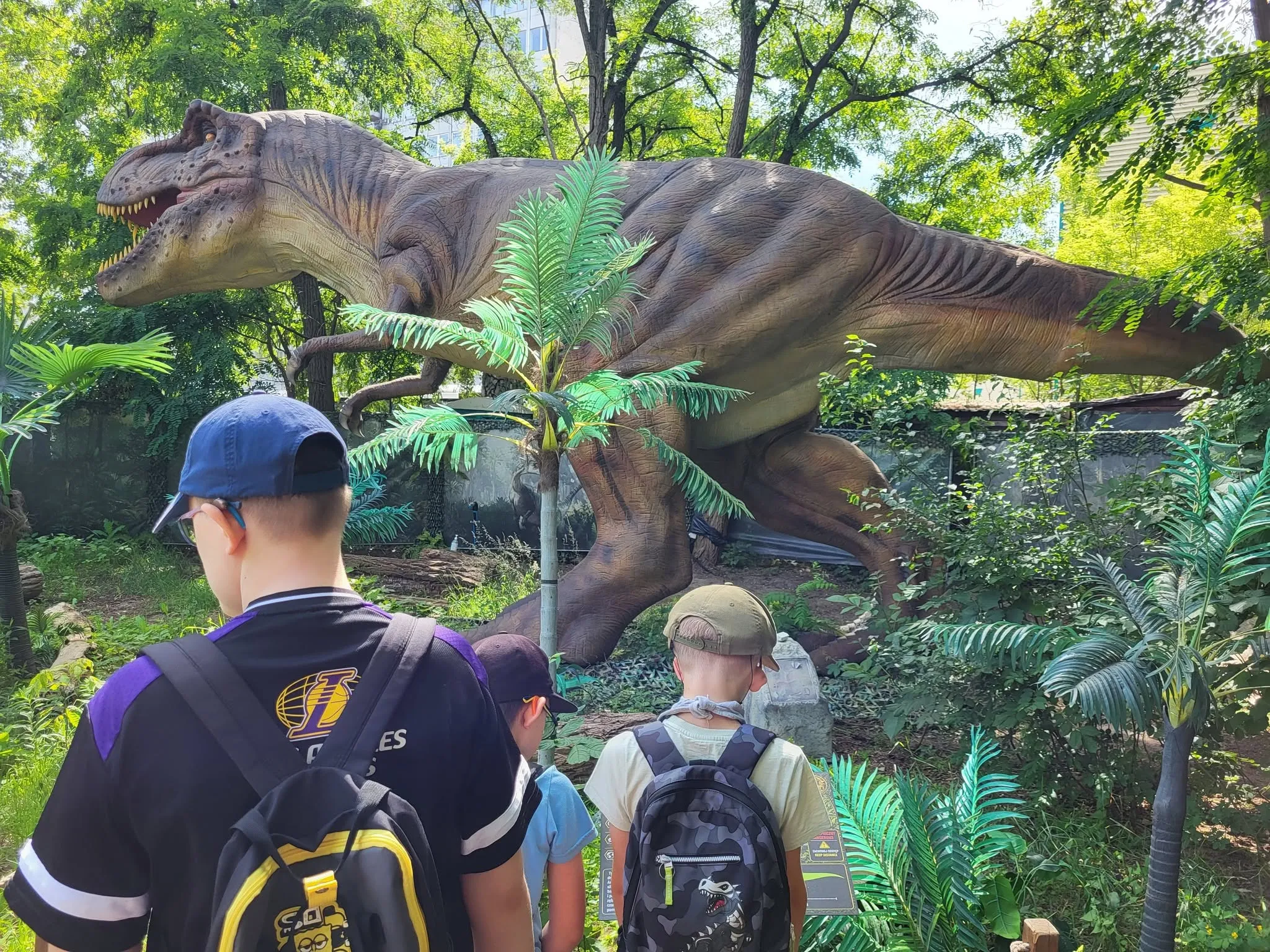 uczniowie podczas wycieczki w parku dinozaurów